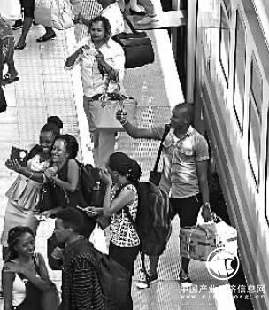 6月9日，乘客到达内罗毕火车站后与火车合影。新华社发