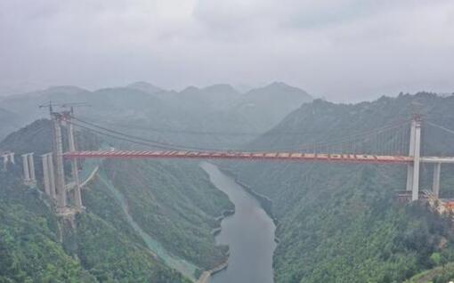 中国山区最宽的钢桁梁悬索桥成功合龙